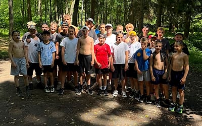 Группа ребят на летних сборах в сосновом лесу