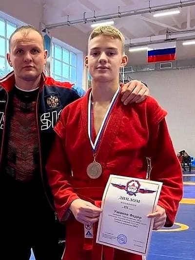 Фёдор Ушаков с медалью и дипломом рядом с тренером Павлом Копейкиным